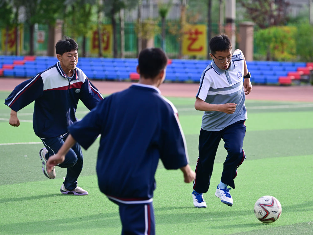 2024年6月18日，在位于青海省西宁市城北区的果洛西宁民族中学，学生们在踢足球。新华社记者 张龙 摄